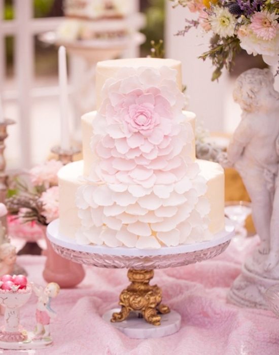 Pastel de bodas con pétalos de rosa cayendo 