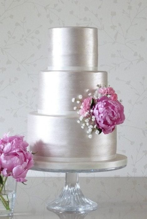 Pastel de bodas en color plateado con una flor rosa 