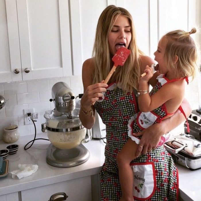 Chica y niña chupando una cuchara con comida 