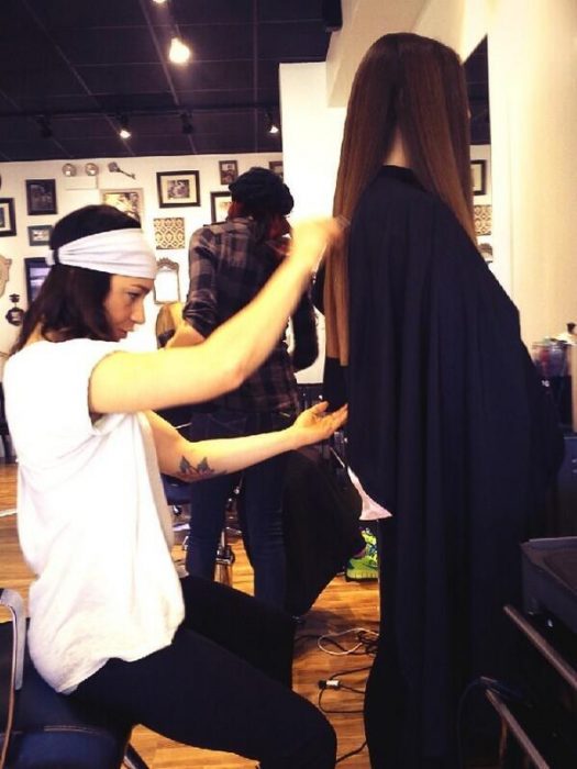 estilista cortando el cabello a una chica de cabello largo 