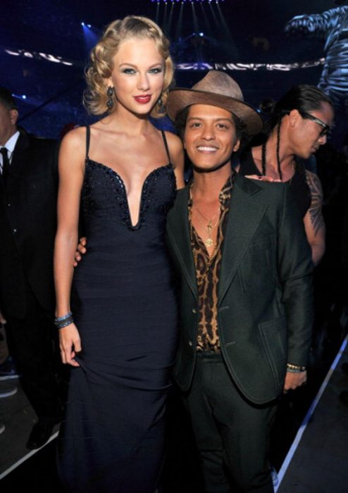 Taylos swift posando junto a bruno mars para una fotografía 