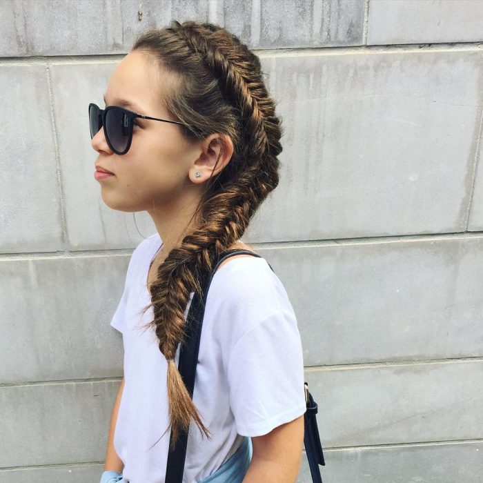 Chica con una trenza cola de pez que está en todo su cabeza 