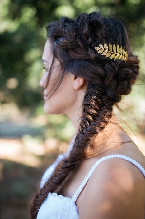 Chica con una trenza cola de pez puesta sobre su hombro y deocrada con una corona de laurel 