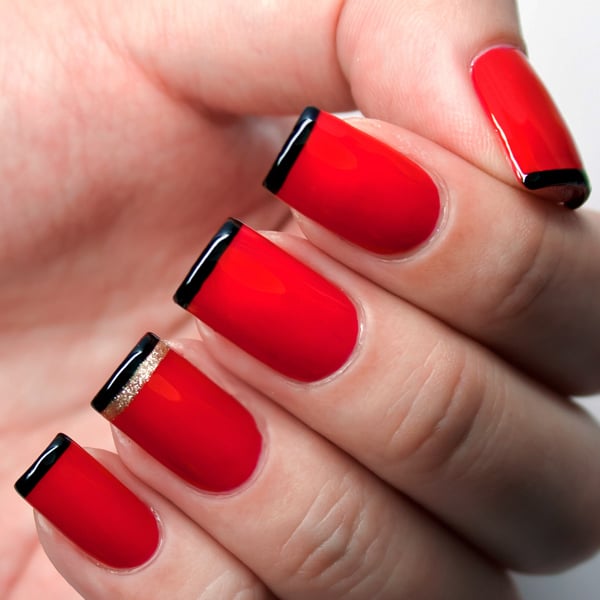 Diseños de uñas en color rojo con líneas de color negro 