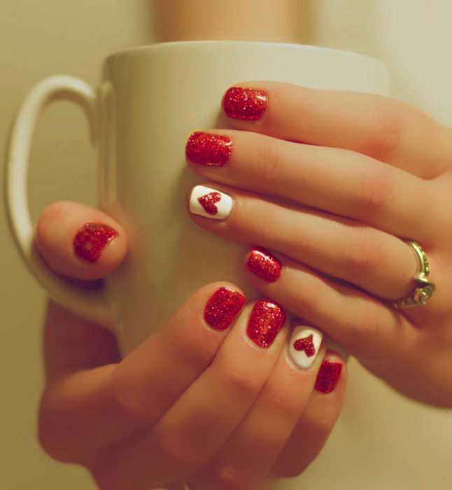 Uñas de color rojo con corazones en color blanco 