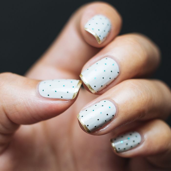 Uñas con diseños minimalistas en color blanco con puntos en color negro 