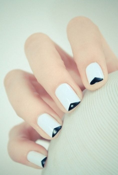 Uñas con diseños minimalistas en color blanco con la punta nen color negro 