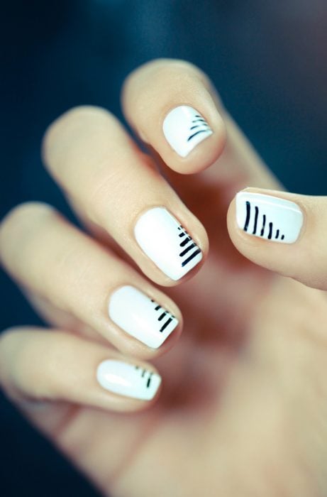 Uñas con diseños minimalistas en color blanco con líneas en color negro 