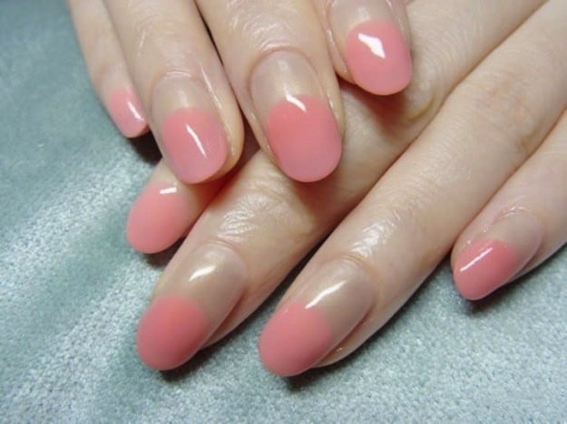 Uñas con diseños minimalistas con la mitad de la uña en color rosa 
