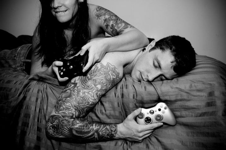 pareja jugando video juegos en la cama xbox