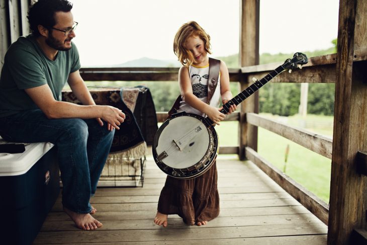 padre con hija tocando guitarra sonrien 