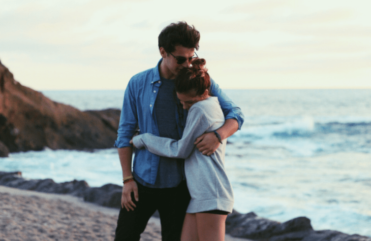 pareja abrazandose en la playa feliz