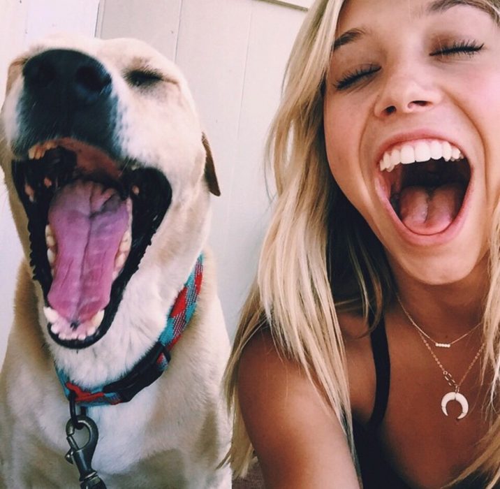 chica sonriendo con perro abriendo la boca feliz