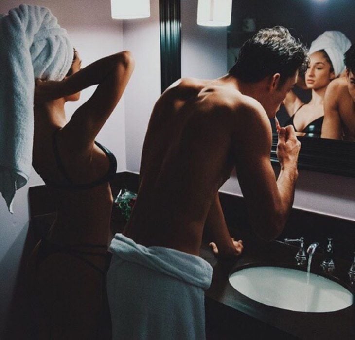 pareja frente al espejo del baño