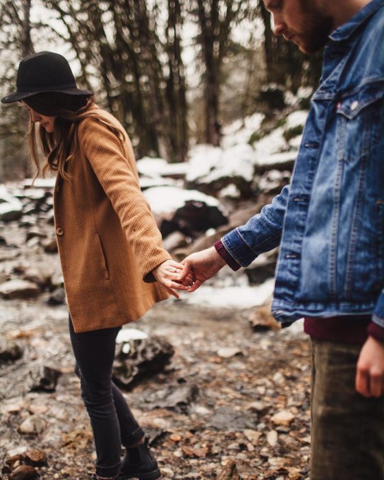 Pareja de novios tomados de las manos caminando 