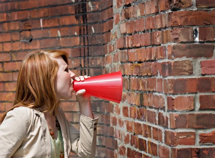 mujer hablando a un muro