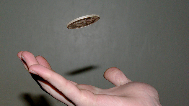 mano con moneda al aire