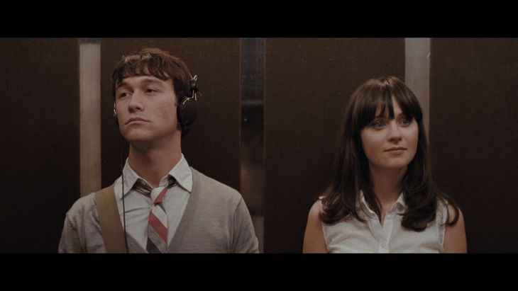 mujer y hombre en un elevador el escuchando musica 