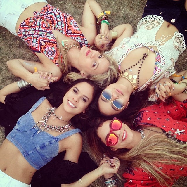 Amigas recostadas en el pasto durante el festival de coachella 