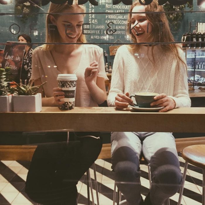 Chicas platicando mientras beben café 