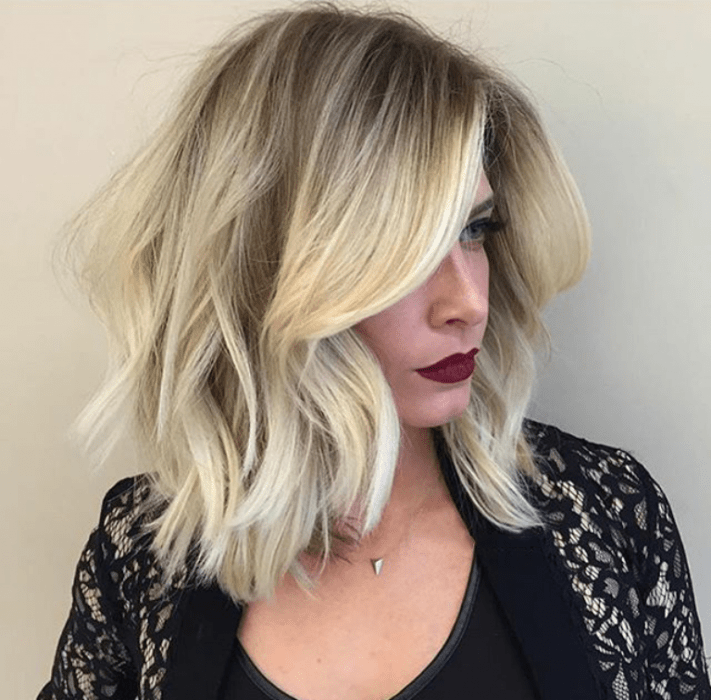 Chica con un cabello en corte long bob teñido en color dorado con la raíz café 