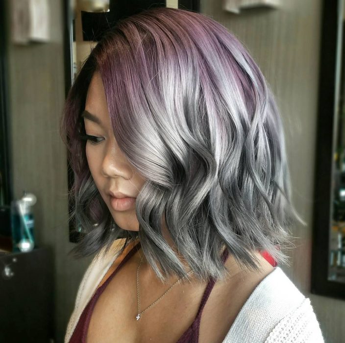 Chica con un corte bob teñido en color gris con la raíz morada 