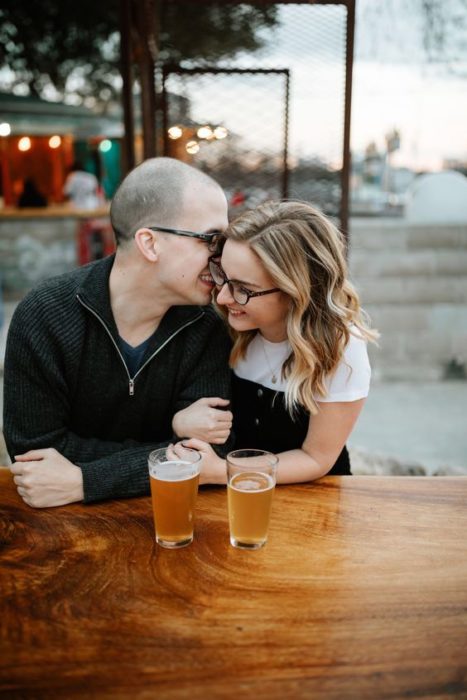 Pareja en un bar tomando una cerveza y conversando