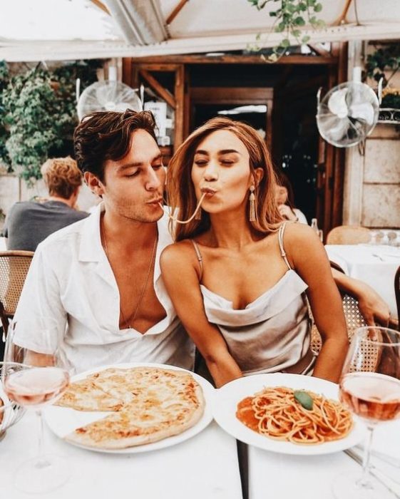 Pareja de novios en un restaurante comiendo pizza y spaguetti