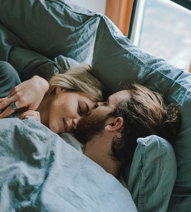 Pareja de novios durmiendo mientras están de viaje en un avión