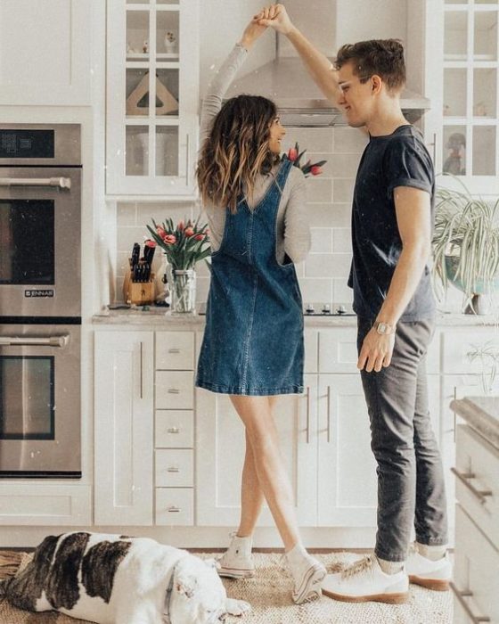 Pareja de novios bailando en la cocina de su casa