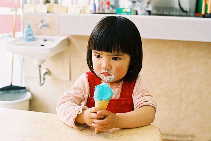 Kotori Kawashima fotografiando a una niña mientras se come un helado 