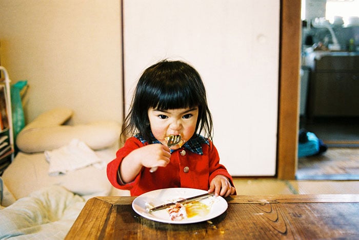 Kotori Kawashima fotografiando a una niña mientras está comiendo 