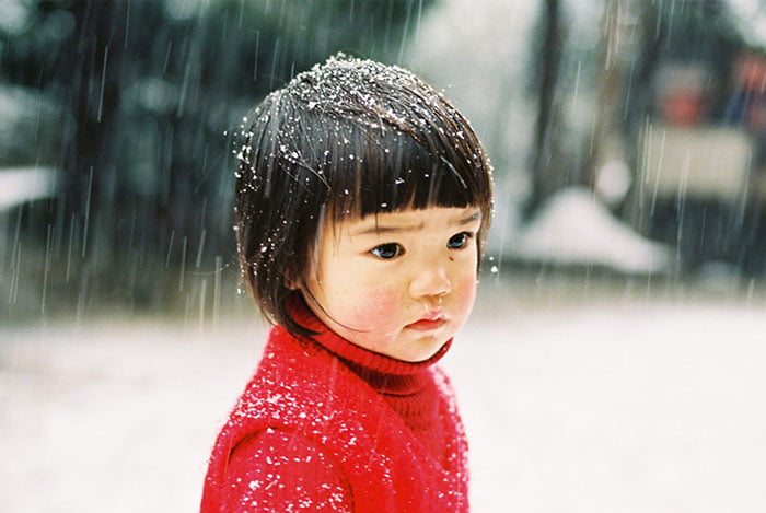 Kotori Kawashima fotografiando a una niña mientras está viendo la nieve caer 