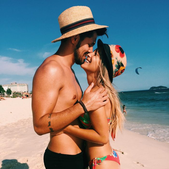 Pareja de novios en la playa sonriendo 