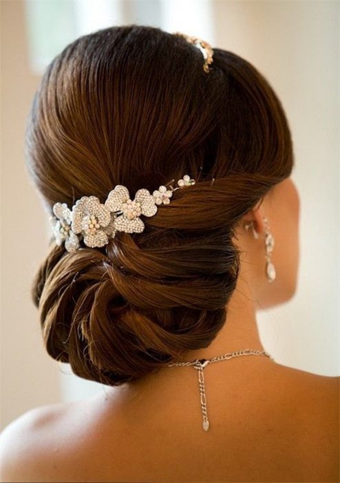 Peinados para el día de tu boda, chica usando un chongo bajo en trenzas 