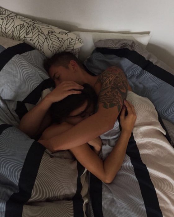 Pareja de novios recostados en la cama durmiendo