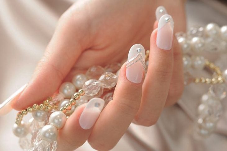 Uñas de color blanco para novia con brillos plateados 