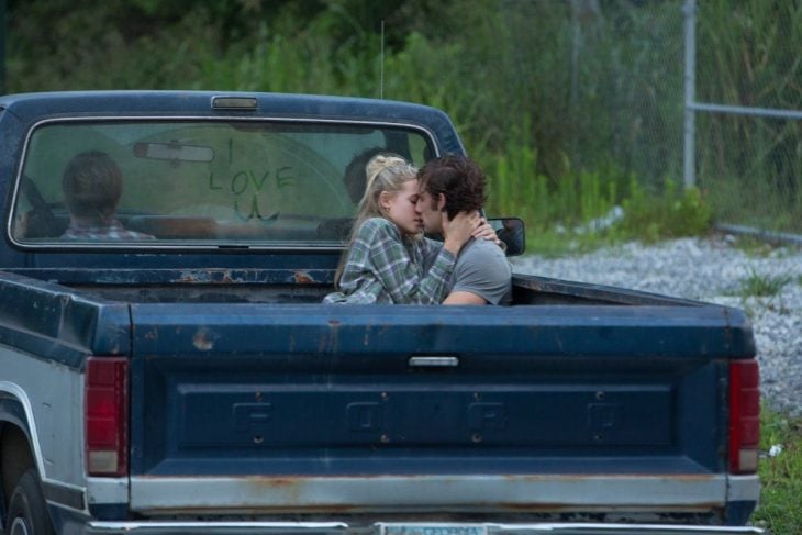 pareja de novios en una camioneta pick up besandose 