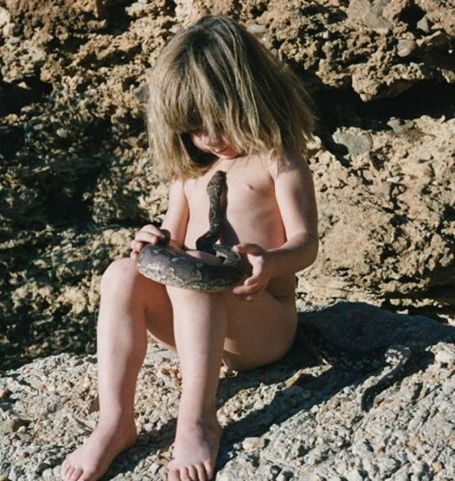 niña tippi sentada jugando con una serpiente 