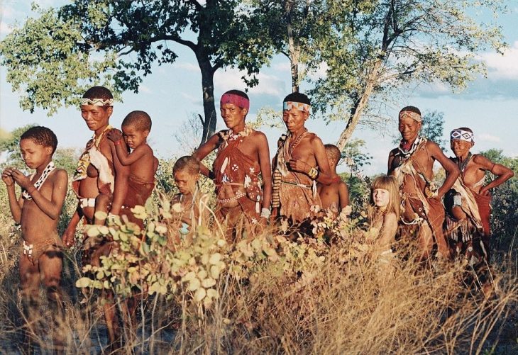 niña tippi caminando en el desierto con tribu africana