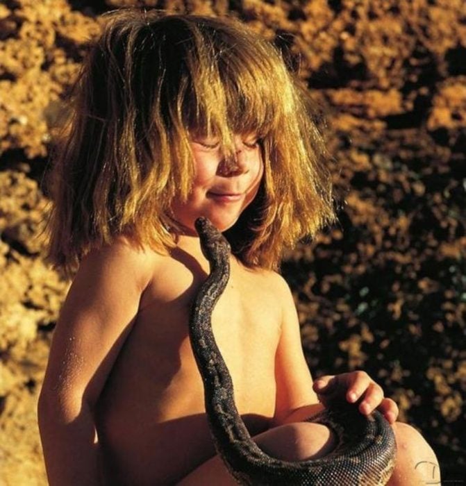 niña tippi sentada con serpiente en sus manos 
