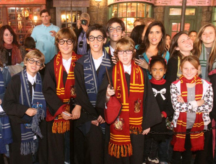 fans de harry potter disfrazados con varitas y libros