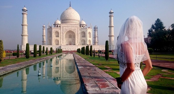 mujer con vestido de novia frente el taj mahal en la inda