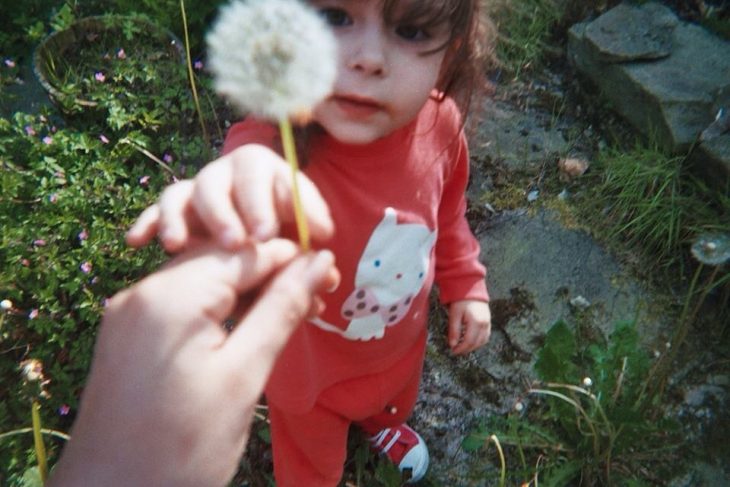 niña con diente de leon en la mano 