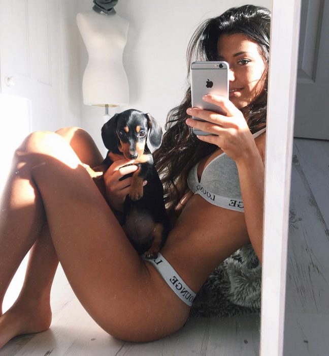 chica de perfil en ropa interior con un perrito selfie espejo 