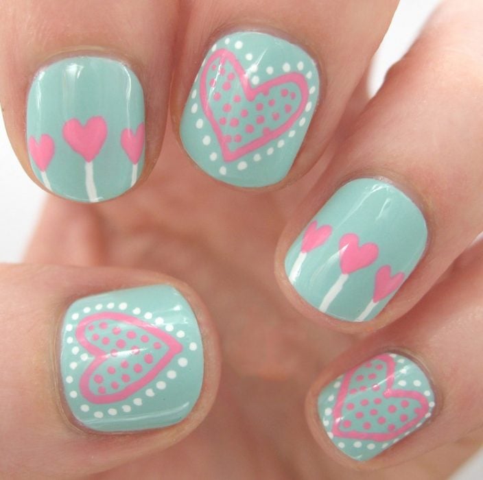 Uñas decoradas en color menta con corazones en color rosa