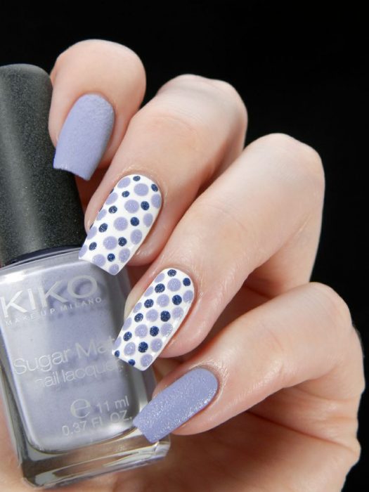 Uñas decoradas en color morado con puntos blancos y azules