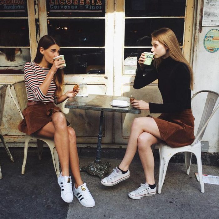 dos mujeres de frente tomando un café 