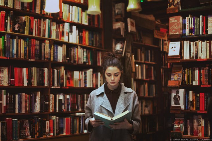 Chica leyendo un libro en una biblioteca