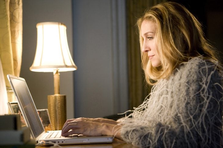 Carrie Bradshaw frente a su computadora escribiendo 